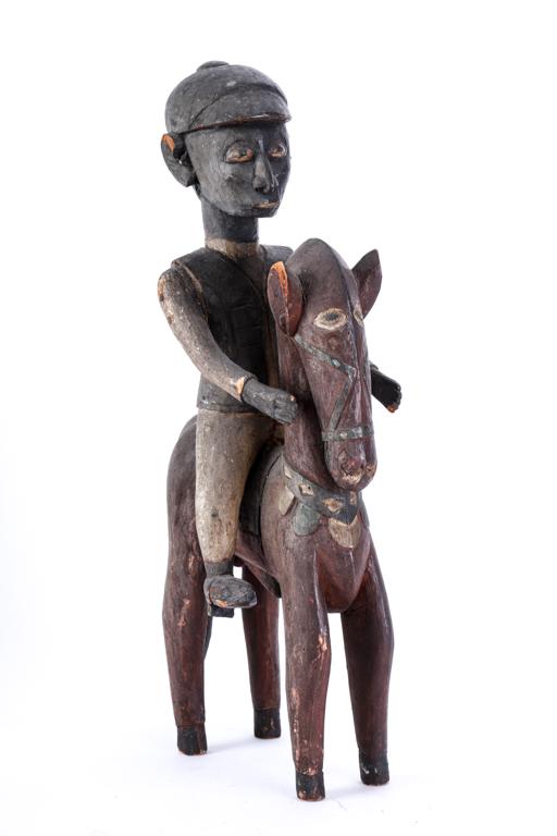 SOUTH WEST AFRICAN EQUESTRIAN FIGURE: In Western attire including riding cap. Carved and painted wood with applied metal strips. c1950. 21 inches.