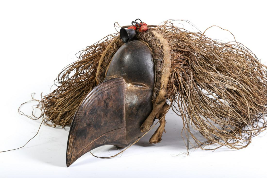 AFRICAN BIRD /BEAK MASK with GRASS and BELL: Hand carved mask with good age. Sewn and braided straw with applied bell, rings and shell. 14 x 9 inches (mask only)