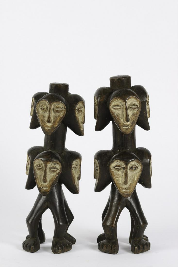 (2) INTERESTING KWELE / NORTHEAST GABON CARVINGS: Masks facing in (4) cardinal directions around with column with anthropoid legs. Dark stained with white delineated faces. 13 1/2 inches