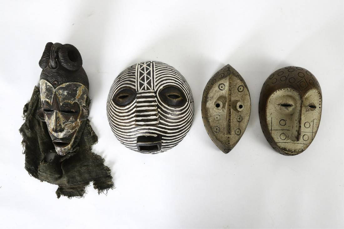 (4) WEST AFRICAN MASKS (Second 1/2 of the 20th c): (2) Possibly Lega. Together with a carved and painted example with extensive wavy facial scarification painted white.