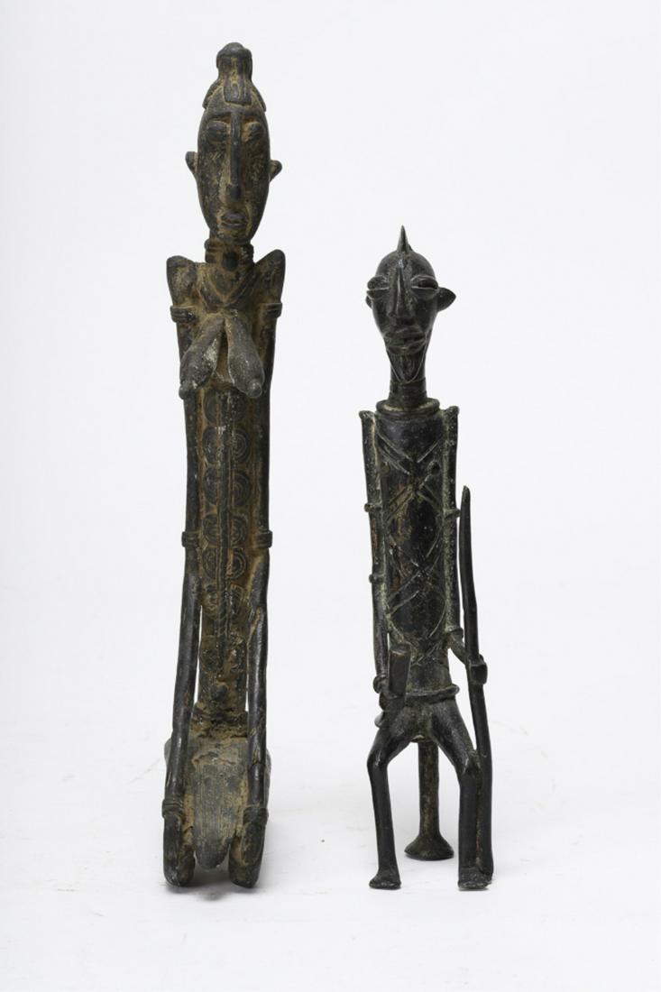 2 CAST BRONZE AFRICAN BENIN & IVORY COAST FIGURES: (1) Depicting an (Early to Mid 20th c) elongated standing chieftain holding a horn and a spear and a (19th /20th c) Benin finely detailed elongated figure of a standing woman. 12 inches