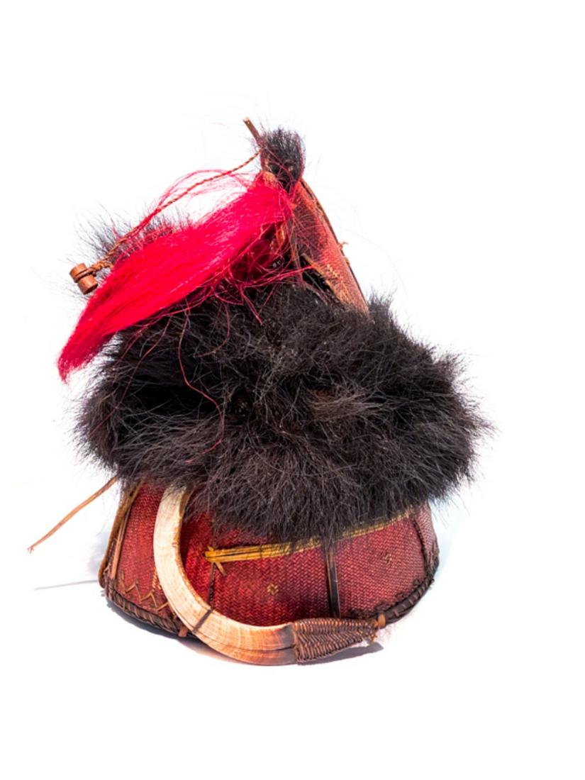 NAGA WARRIORS HAT WITH BOAR TUSK ADORNMENT: Woven and dyed hat decorated with goat hair and boar's tusk . 10 x 8 inches