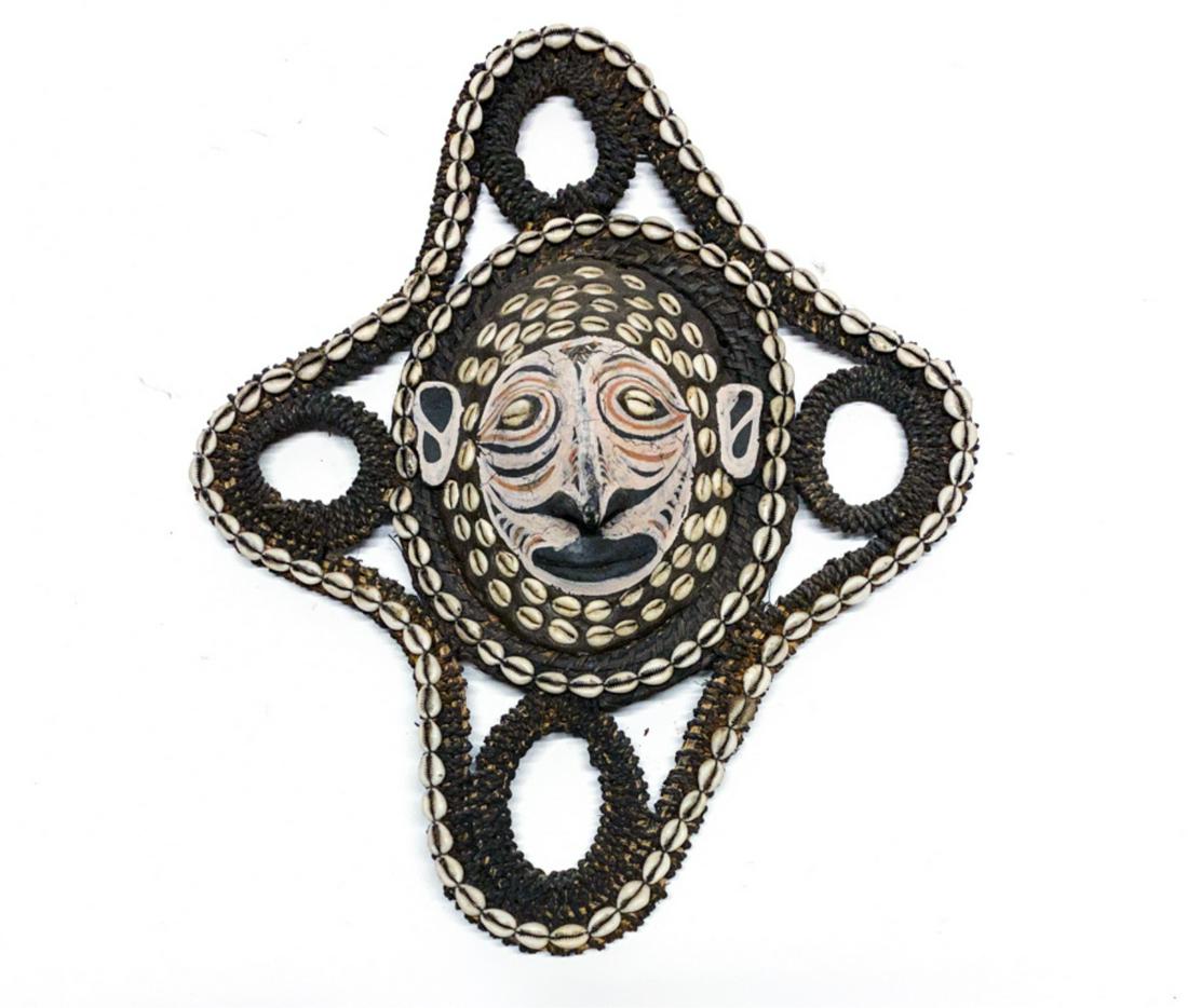 SEPIK RIVER TURTLE SHELL MASK, PAPUA NEW GUINEA: Center turtle shell with painted face and shell design framed in a woven and shell decorated housing. Made by the artist Bernadita Sui. 20 x 16 inches.