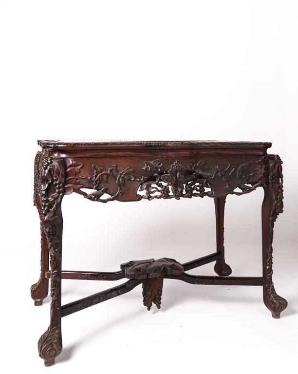 CHINESE CARVED ROSEWOOD CONSOLE TABLE: Shaped top banded with prunis blossoms carved in low relief. Conforming serpentine apron is carved and pierced with grape vines which continue down each leg. Cross stretcher with heavily carved drop. 