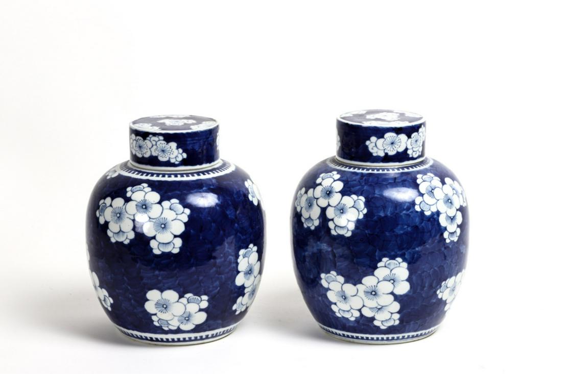 PAIR OF CHINESE PORCELAIN GINGER JARS: Decorated with prunus blossoms on a blue ground. unmarked. 10 1/2 inches, 14 inches on pieced bulbous stands. Condition: Good, stands show evidence of repairs Temp No 4510