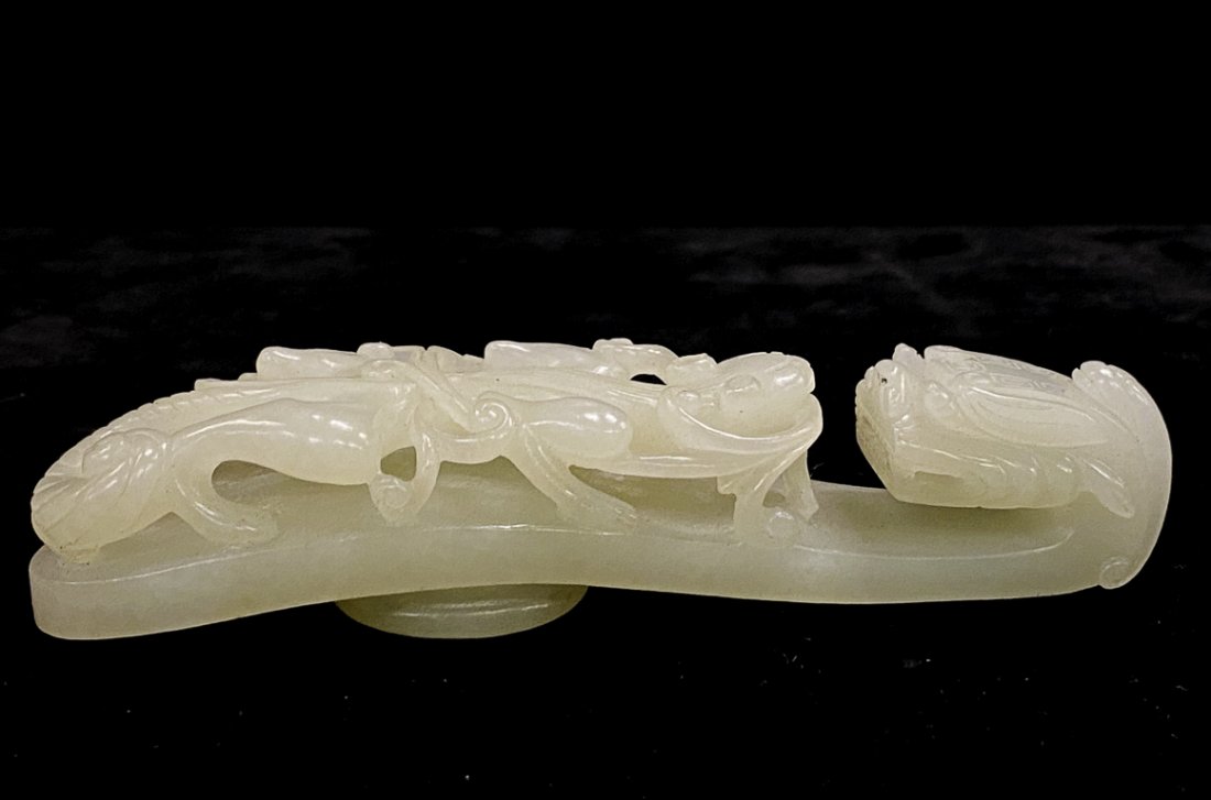 CHINESE JADE BELT HOOK CARVED with a CHILONG: Pale green color, carved and pierced with a dragon-head clasp and a scrolling chilong. 4 3/4 inches.