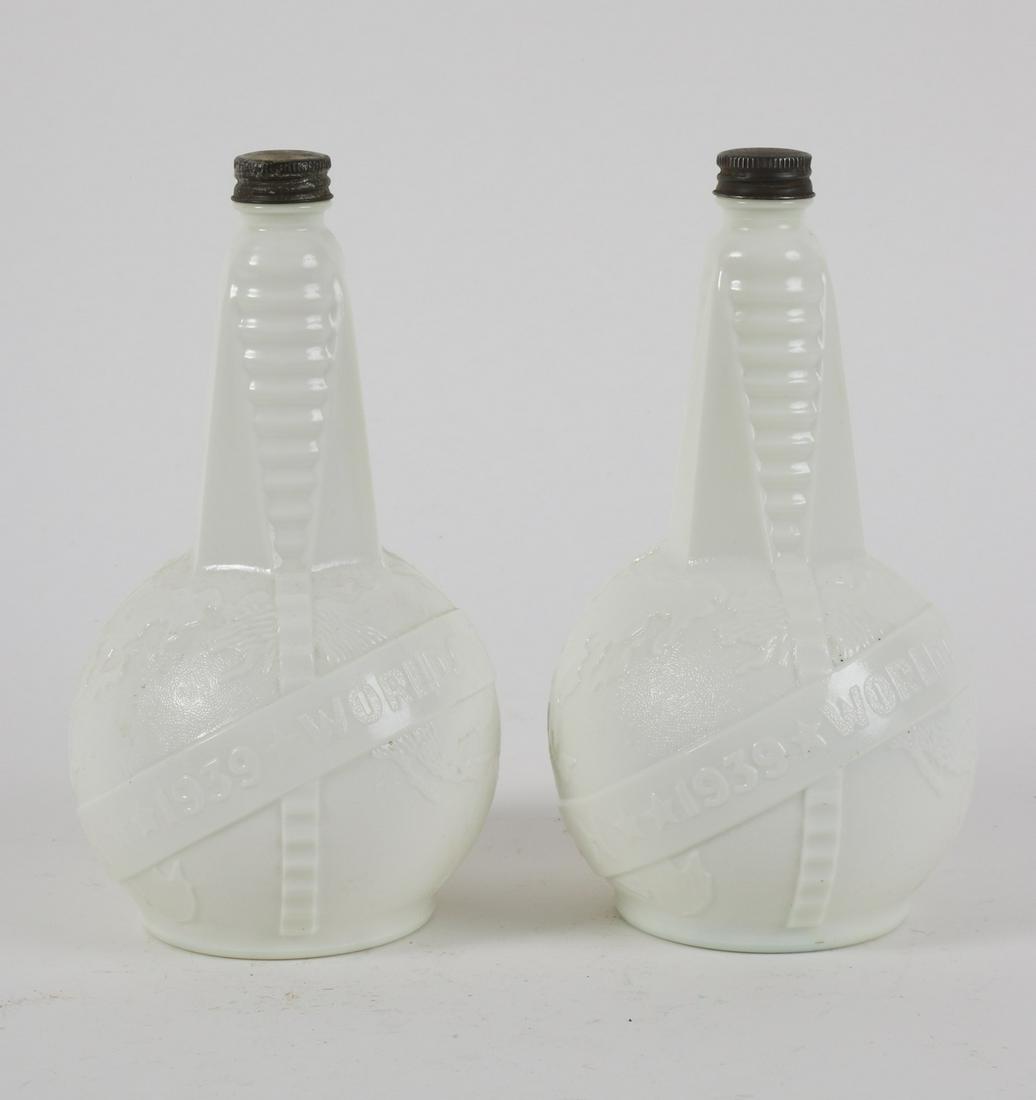 (2) 1939 World's Fair Art Deco Bottles: Molded milk glass with tin twist caps. 9 inches