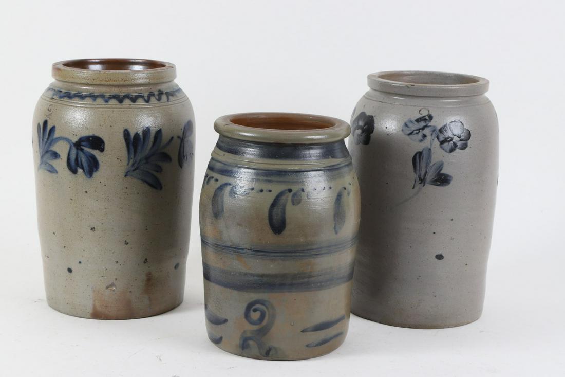 (3) Salt Glazed Stoneware Crocks: Including : (2) Two gallon examples stenciled “2” and one painted“ in cobalt. Each decorated in cobalt with floral motifs including pansies, tulip sprays and graduating leaves. 14, 13 ½ and 12 
