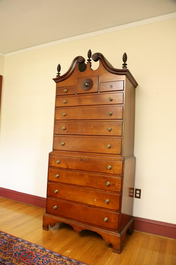 (18th c) Chippendale Cherry Chest on Chest: Bonnet top with flanking pinwheels,(3) flame finials and carved center drawer. Top case includes (5) molded graduating drawers. The lower molded case with (4) matching above molded base with shaped br