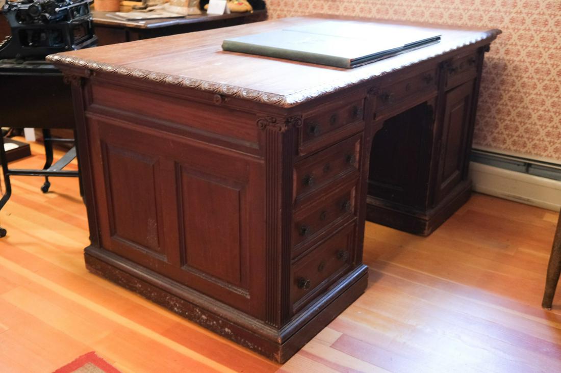 (2) BANK MAHOGANY PARTNERS DESK: Molded top with compartmentalized center drawer is flanked by (4) Graduating drawers and single drawer above a cabinet. ( 4) Pilasters with Ionian capitals bookend each bank. Each paneled side has a s