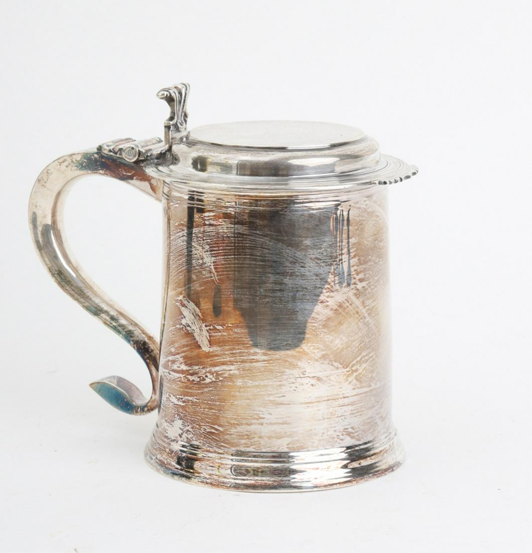1902 HAND WROUGHT STERLING SILVER LIDDED TANKARD: A hand wrought reproduction of an (18th c) William IV Lidded Tankard / Beer Mug in a classic canted form. Substantial scroll handle and a molded flat hinged lid with a scrolled thumb piece. signed and