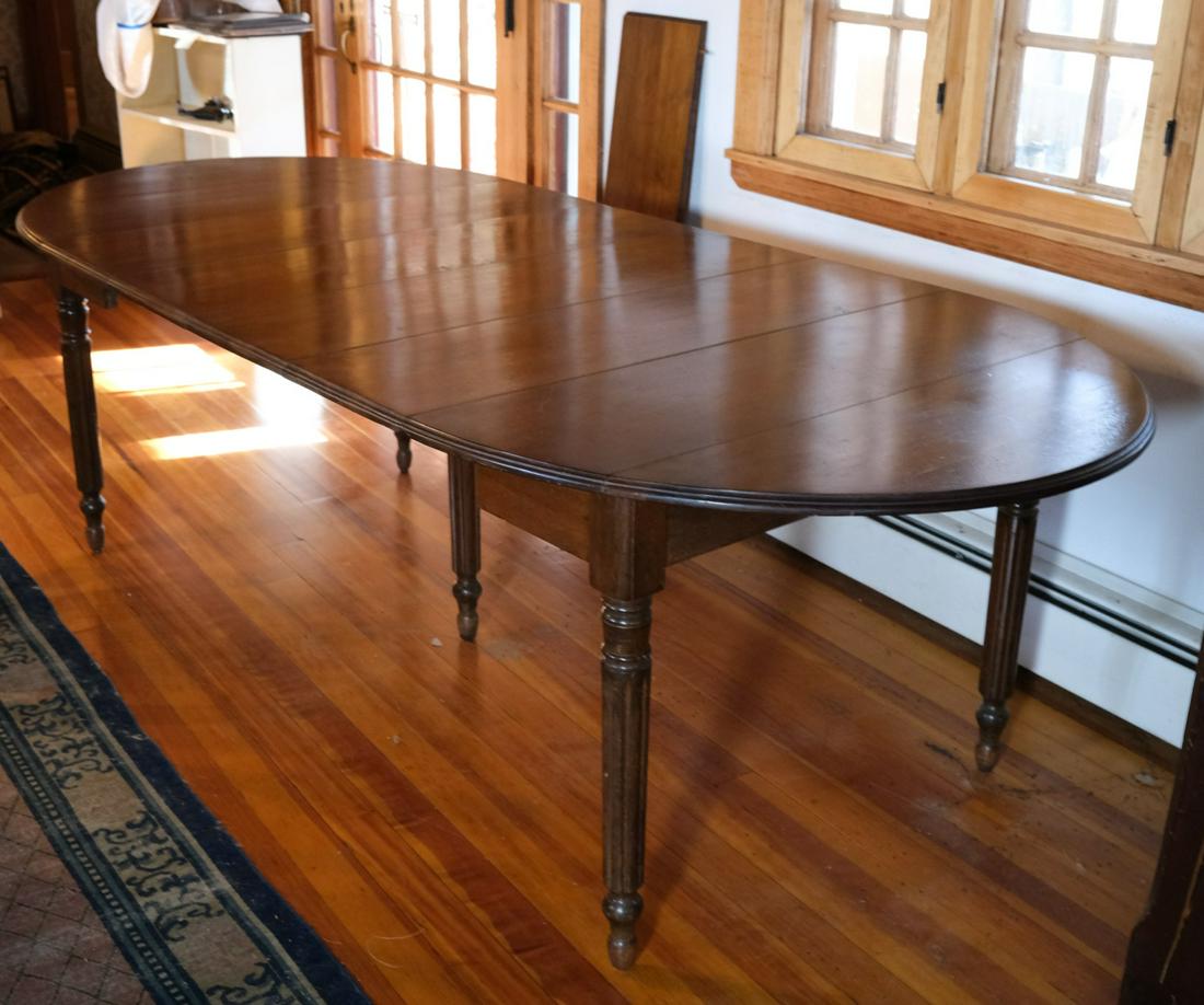 SHERATON STYLE MAHOGANY DINING ROOM TABLE: Molded top with (5) leaves raised on turned and reeded legs with tapered ball feet. 29 x 108 x 42 inches. (including leaves)