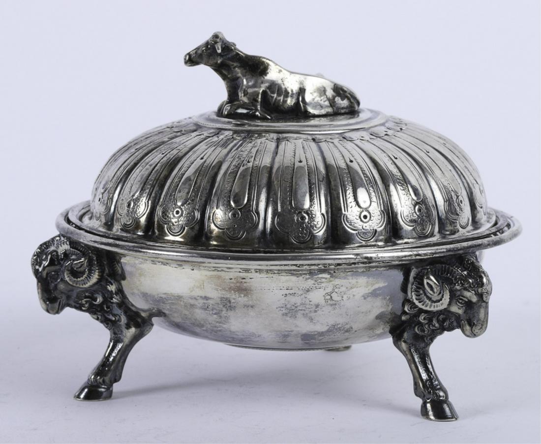 TIFFANY & COMPANY COIN SILVER BUTTER DISH: Surmounted with an applied full-figured cow resting in a bed of grass over a repeating petalled cover. The bowl with inset strainer is raised on (3) ram head and hoof feet. signed Tiffany & Co. Gold a
