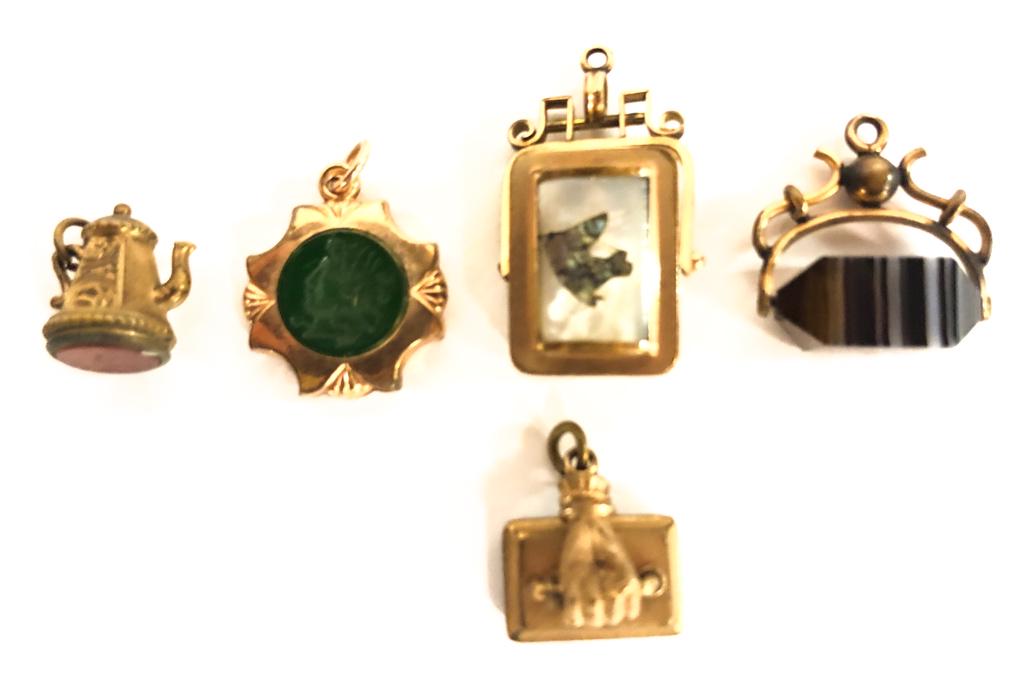 (5) ANTIQUE VICTORIAN WATCH FOBS W/ STONES: Including: Locket fob set with mother-of-pearl which is inlaid with the head of a horse. Hand on handle, Teapot, Figural intaglio cut example, and a banded agate which swivels. (Hand and teapot are se