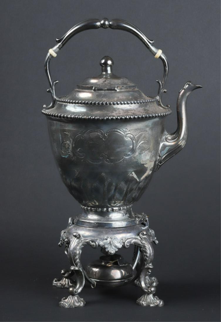 REED AND BARTON SILVER PLATED KETTLE ON STAND: Impressive ornate kettle can be removed or tilted on stand. Footed stand holds wick and oil to keep water hot. Replated by Gorham and Company. 15 1/2 inches