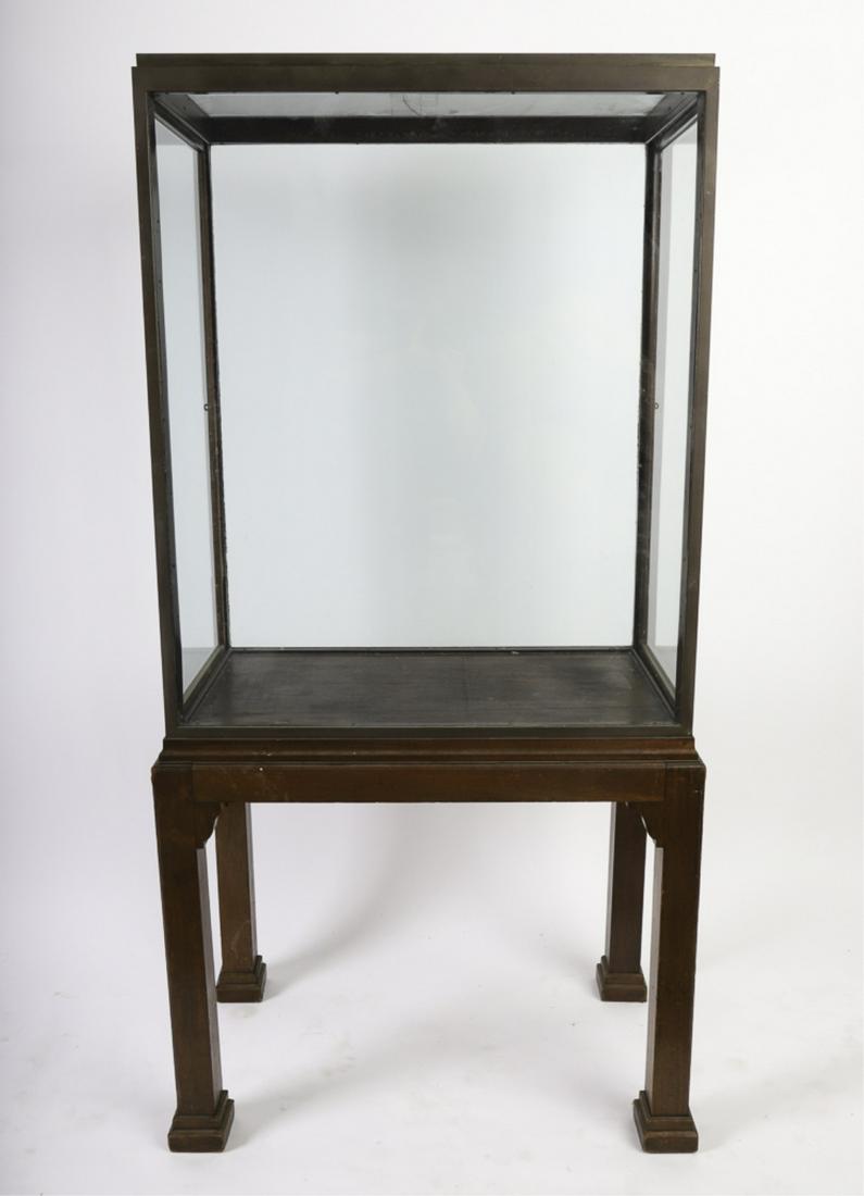 BRONZE DISPLAY CASE ON MAHOGANY STAND: Asian inspired design with stepped top and Chippendale base. (2) hinged doors open from each side. 67 x 33 x 19 inches.