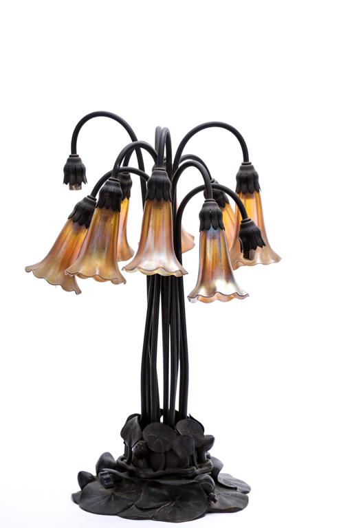 TIFFANY STUDIOS NEW YORK (10) LIGHT TABLE LAMP: (10) Light favrile glass lamp with cast bronze lily pad base. signed and numbered 881. 20 1/4 inches.