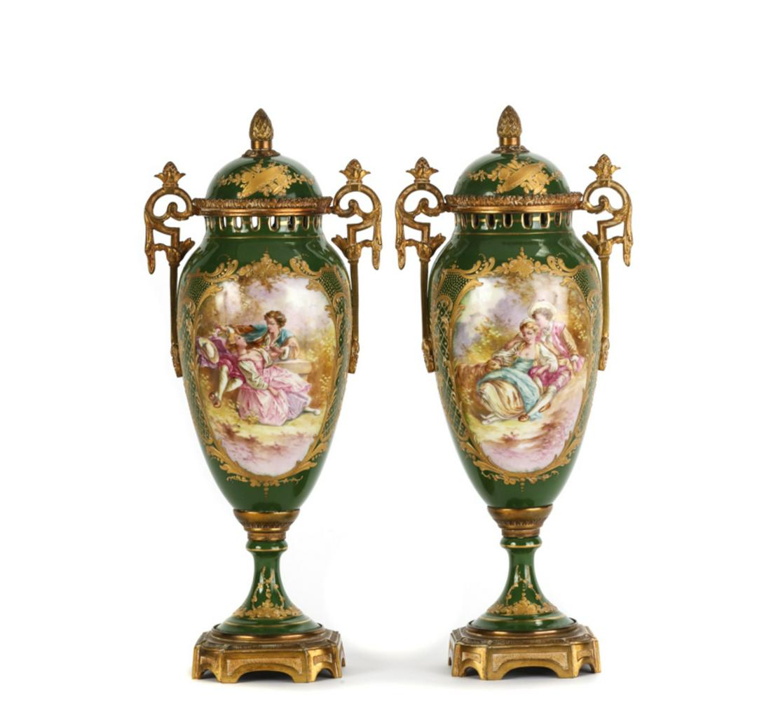 PAIR OF FRENCH PORCELAIN URNS with ORMOLU MOUNTS: Hand painted with courting scenes and landscapes. Nicely embellished with gilt instruments, lattice work and filigree. signed A. Bost. 14 3/4 inches. Weighted bases cast France.