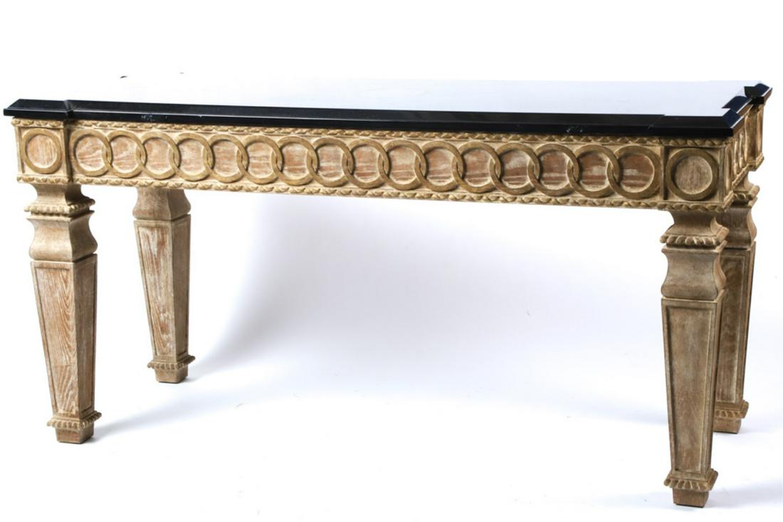 PAIR OF DESIGNER QUALITY MARBLE TOP TABLES: Elaborately carved pickle treaded wood with interlocking rings, roping and beadwork.. Offset legs support a conforming black marble molded top. 35 x 70 x 27 1/2 inches.