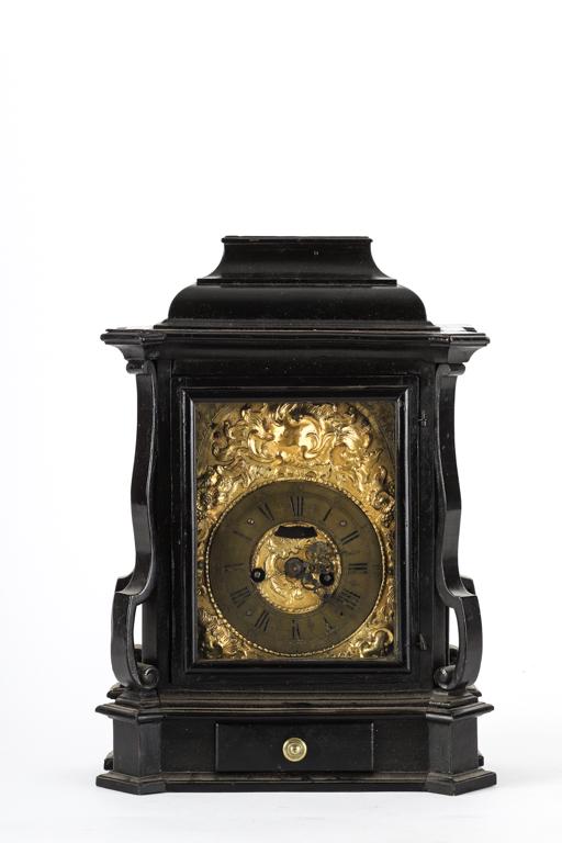 FRENCH MANTLE CLOCK with ROCOCO PRESSED BRASS DIAL: 4 3/4 inch dial with chiming movement and engraved spandrels. Ebonized aesthetic movement bracket form with lower key drawer. 15 1/4 inches