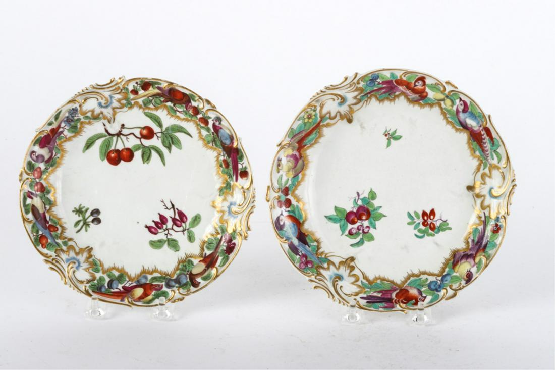 TWO SIMILAR (18th c) CHELSEA PLATES: Rococo molded rims hand painted with birds and fruits, and highlighted with gold. 7 1/2 inches.