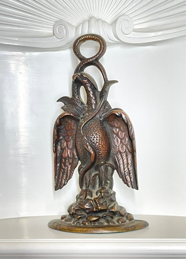 ENGLISH CAST EAGLE AND SNAKE DOORSTOP: Last quarter of the 19th century, brown patina depicting an eagle perched on rocks, intertwined with snakes, weighted base, 13.5 x 7.5 x 2.75 inches