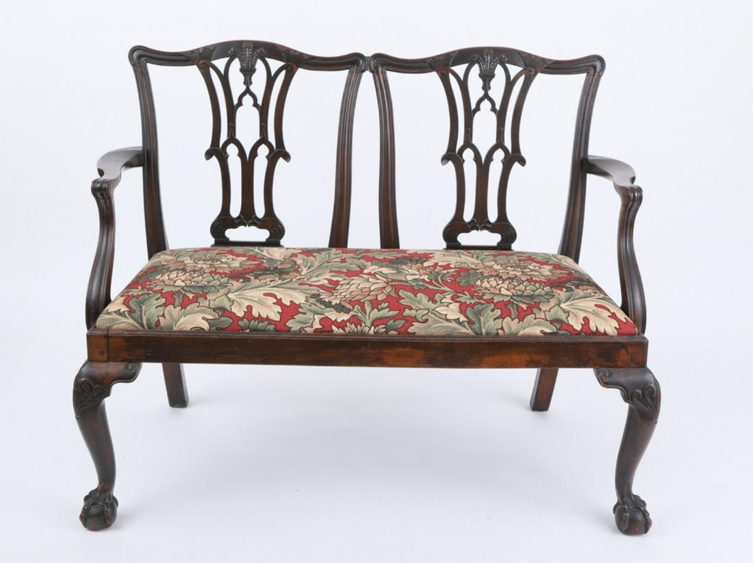ENGLISH CHIPPENDALE STYLE SETTEE: Mahogany, last half of the 19th century, double chair-back with Prince of Wale's carved feathers, pierced splats, scrolled arms above a slip seat, raised on frontal cabriole legs ending in ball and cl