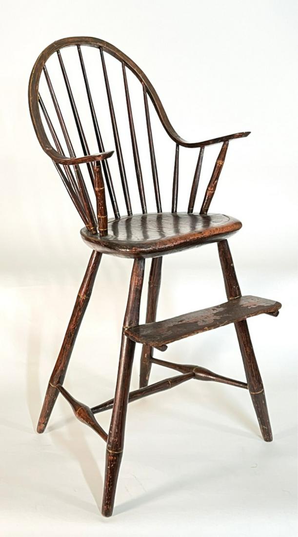 AMERICAN WINDSOR CONTINUOUS ARM HIGHCHAIR: A fine example of a late 18th to early 19th century Windsor with bamboo turnings, in a late 19th century red grained surface, the underside old label affixed "This chair restored to it's original fini