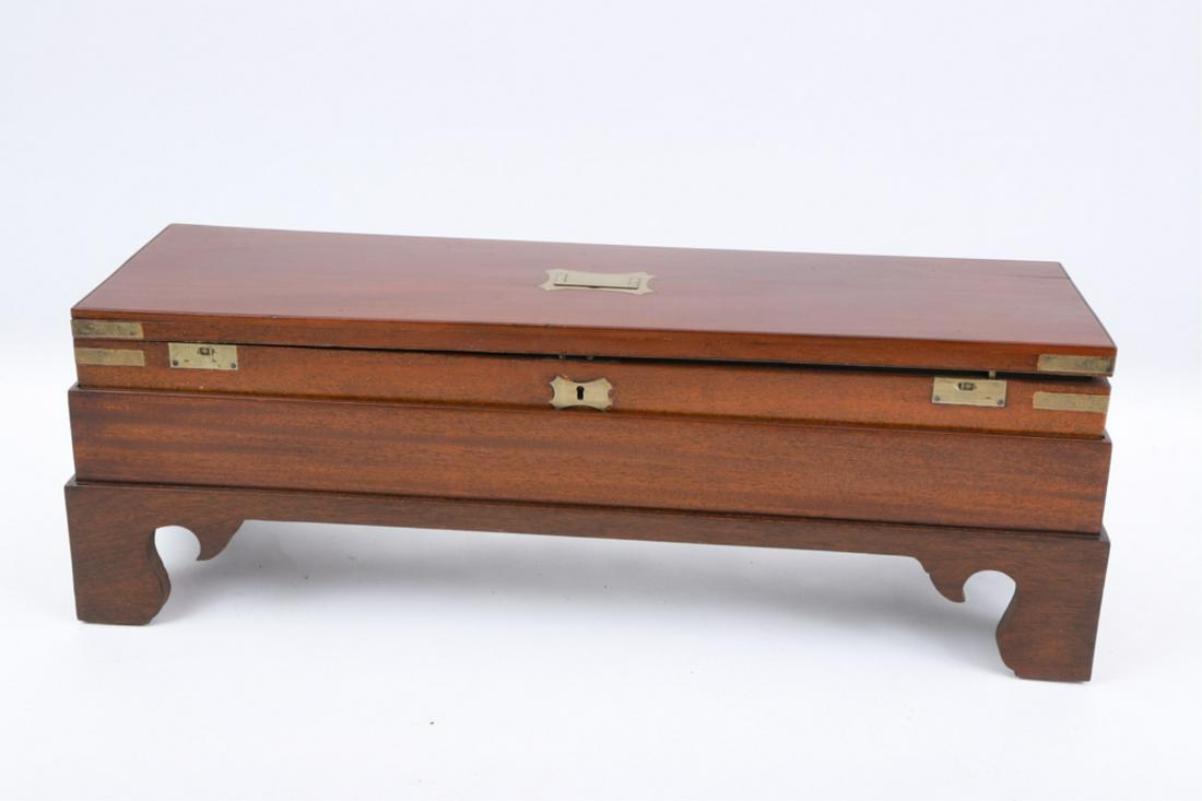 PURDY MAHOGANY BOX ON STAND: Mid 19th century brass bound Purdey English shotgun box with recessed handle, opens to reveal a green baze interior, retaining the original Purdy label, resting on a modern custom made bracket footed 