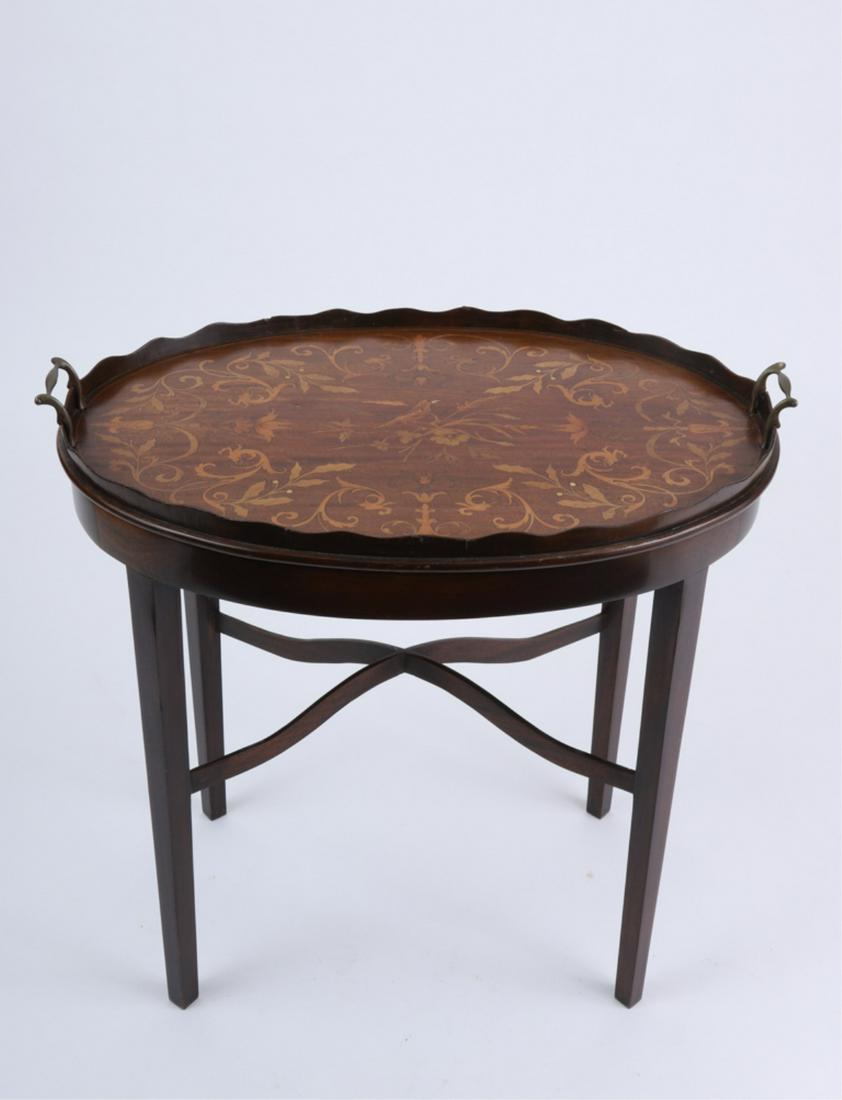 ENGLISH MARQUETRY INLAID TRAY ON STAND: Circa 1900, oval form with double brass handles, scalloped gallery, inlaid with various woods in a floral motif centered with a crowned bird, rests on a custom made later stand with cross stretchers, 