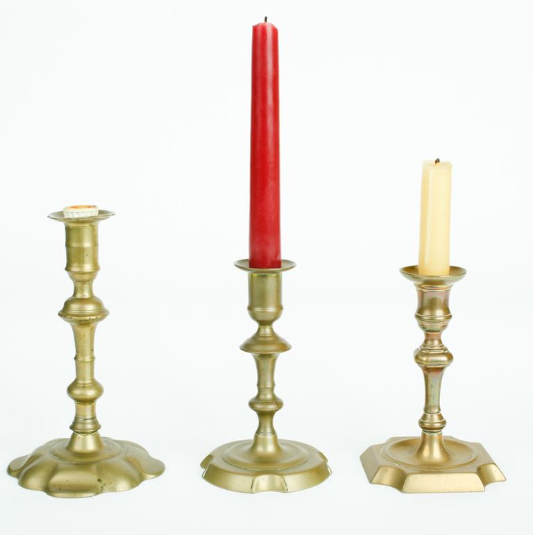 THREE EARLY19TH CENTURY ENGLISH CANDLESTICKS: One bell metal with scalloped circular foot, two brass, tallest 7.5 inches
