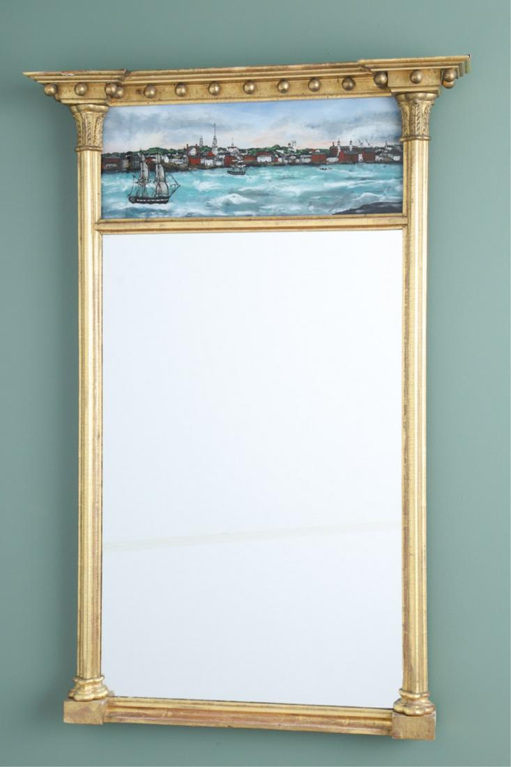 FEDERAL GILT AND EGLOMISE MIRROR: trefoil columns with acanthus leaf carving, a later eglomise panel depicts a 19th century Newburyport harbor scene, 33 x 22 x 3.5 inches