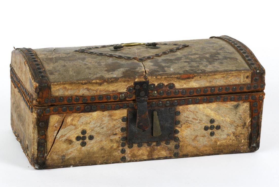 DOME TOP DOCUMENT BOX by SHAW & SAWYER: Wooden box covered in horse hide, leather straps and brass tacks. Interior is covered in period newsprint. 6 x 15 x 8 inches. Condition: Hide in fair condition, (2) holes in top Temp No 6489