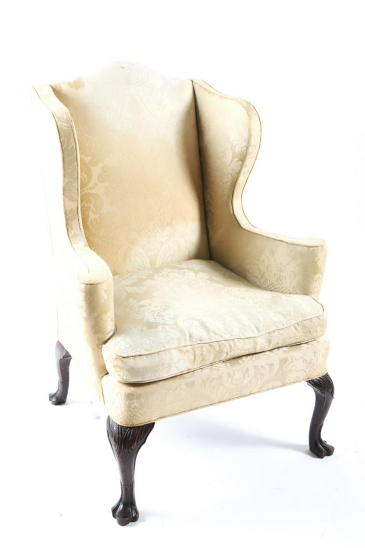 FINE CUSTOM WING BACK EASY CHAIR: Raised on cabriole legs with acanthus leaf carved knees and trifid feet. 45 x 33 x 34 inches. Condition: Good, damask upholstery has light staining, fading and wear to arm Temp No 6321