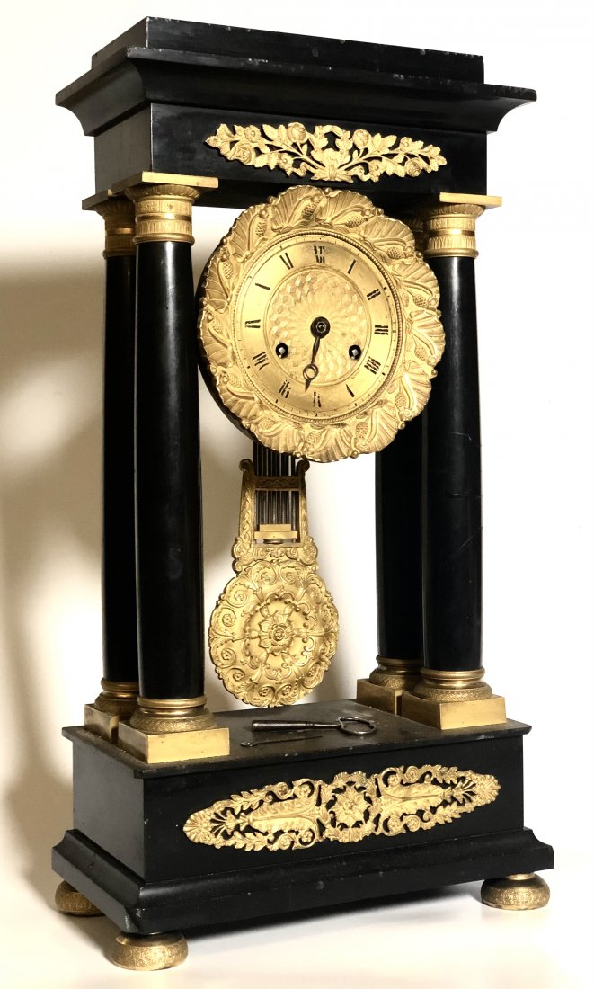 FRENCH ORMOLU MOUNTED SLATE PORTICO CLOCK: 3 3/4 inch dial with chiming movement and wreath and laurel friezes. 20 inches (including lion not original to the clock. Condition: (1) hand absent Temp No 6085