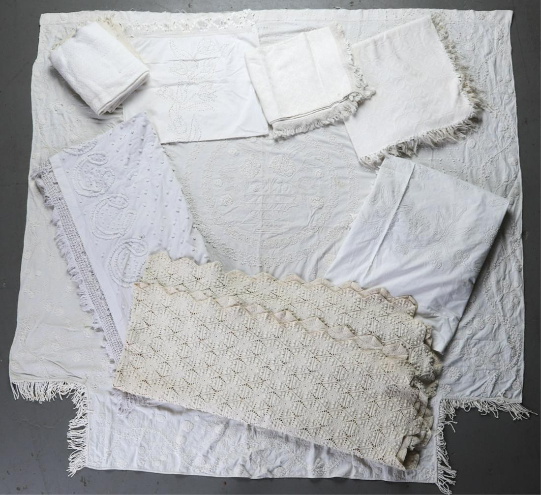 GROUPING OF WHITE LINENS INCLUDING TABLE CLOTHS: and Spreads. In a variety of patterns. Condition: Overall good, minor stains Temp No 6527