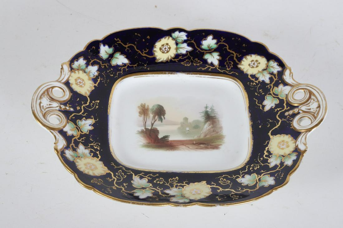 ENGLISH PORCELAIN RAISED (2) HANDLE TRAY: Hand painted with a romantic landscape. 2 1/2 x 11 x 9 inches Condition: Good, minor wear to gilding Temp No 6418