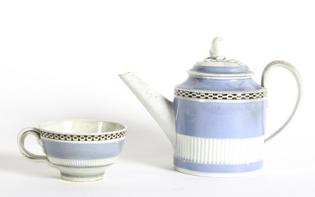 LEEDS MOCHA PEARLWARE TEAPOT and TEA CUP: Checkered bands and acorn finial. 4 3/4 inches Condition: Flea bite to tip of spout and rim of teapot. Fleabites to foot of cup Temp No 6116