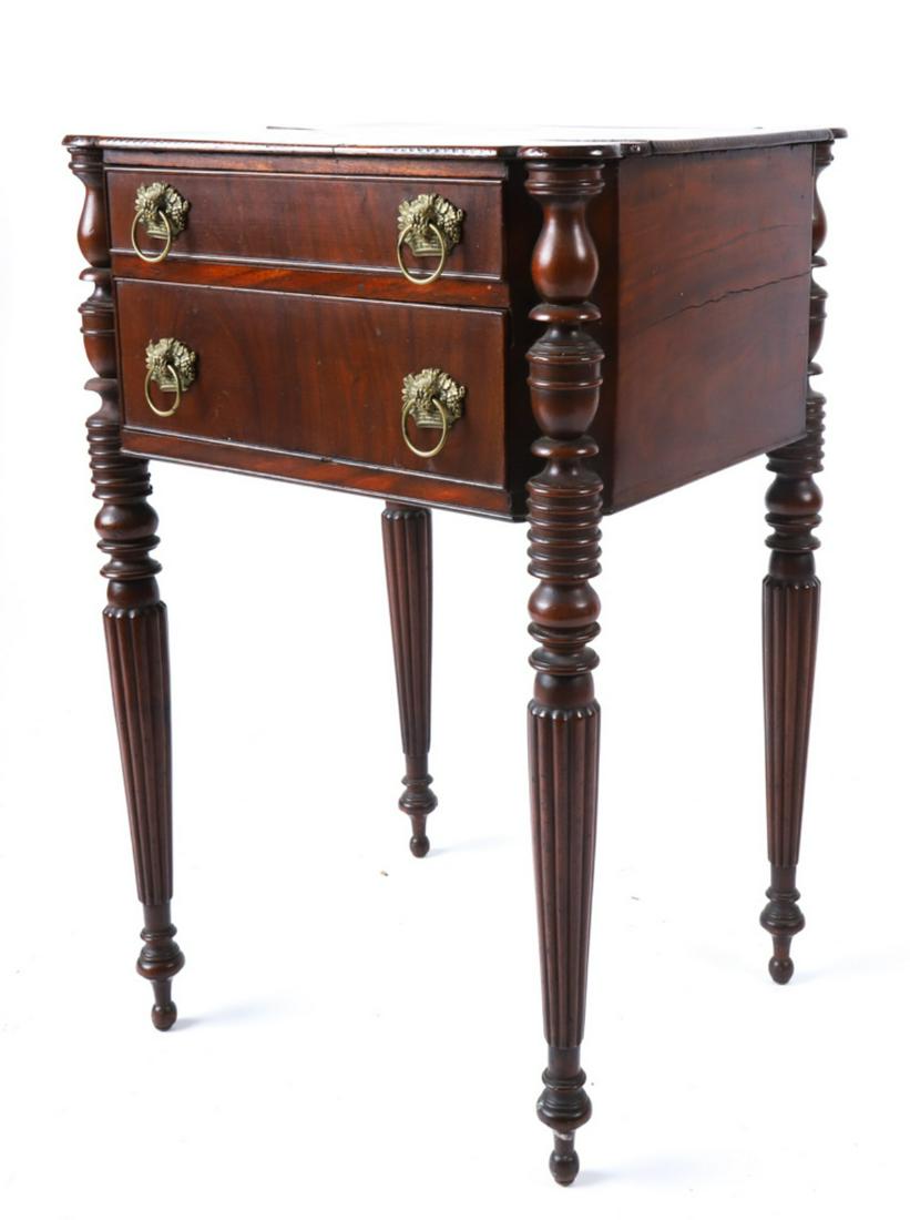 SHERATON MAHOGANY (2) DRAWER STAND: Turret top with vase and spool turned, reeded legs. Graduating cock-beaded drawers with basket of grapes brass pulls. 29 x 19 x 16 inches. Condition: Old repairs Temp No 6258
