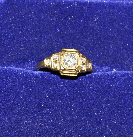 Lady's 18k gold ring set with a 1/2 ct center ston: Lady's 18k gold ring set with a 1/2 ct center stone and six smaller diamonds