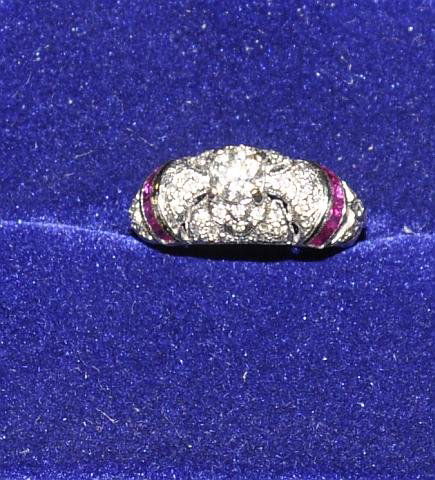 Lady's art deco 18k white gold ring with 1/2 ct di: Lady's art deco 18k white gold ring with 1/2 ct diamond center stone. The band is encrusted with diamond chips and channel set rubies