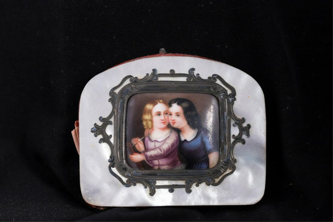 NACRE PURSE SET with PORCELAIN MINIATURE: Accordion-hinged silk purse covered in mother of pearl and set with a silver framed porcelain miniature of (2) young girls writing (unsigned). 2 1/2 x 3 inches.