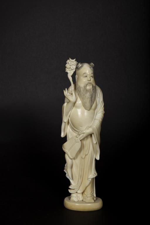 19th/20th century Japanese ivory carving of a man: 19th/20th century Japanese ivory carving of a man holding a floral arrangement. Height: 8 1/2"