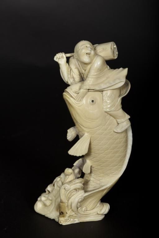 19th/20th century Japanese ivory carving of a man: 19th/20th century Japanese ivory carving of a man on fish. Height: 5 1/2"