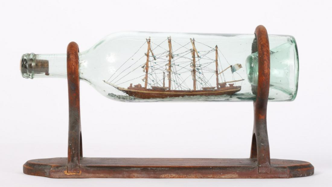 (4) MASTED TALL SHIP IN A BOTTLE: Presented on an interesting custom stand. 7 1/2 x 13 x 4 inches.