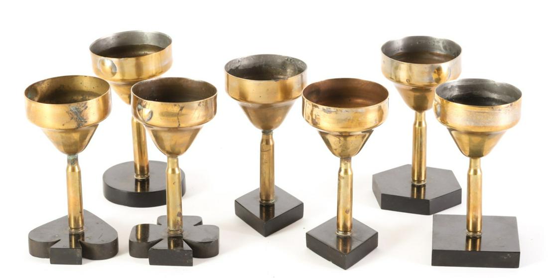 (7) TRENCH ART BRIDGE CUPS: Brass shell casings supported by Bakelite shaped feet with diamonds, spades and clubs as well as other geometric shapes. 5 inches