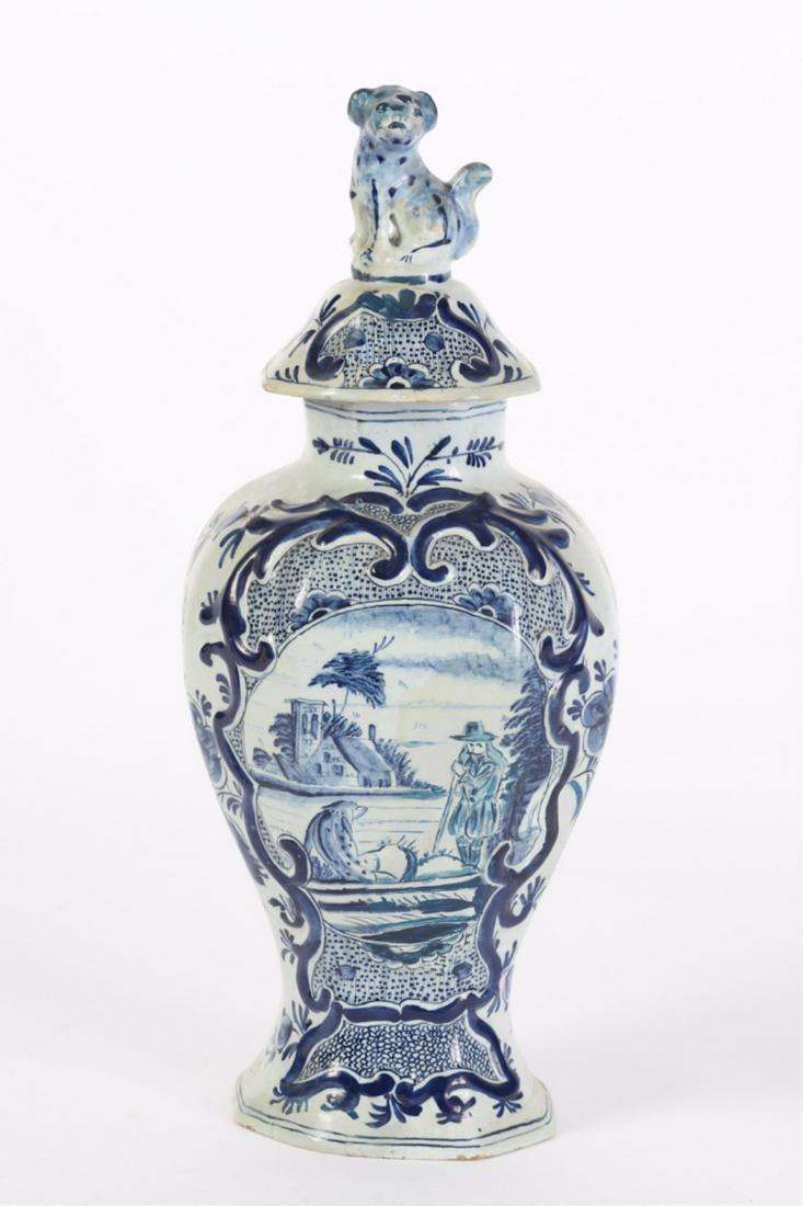 OCTAGONAL DELFT URN with RAISED CARTOUCHE: Hand painted scene on a man and his dog on a punt, diaper patterns and floral sprays. Cover with full figured dog. 16 1/2 inches
