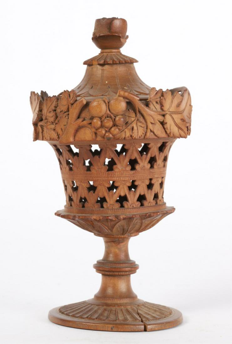 TURNED, CARVED & PIERCED TREEN CONTAINER: Urn-form carved with floral finial, lancet foliates and grape vines. 6 1/2 inches