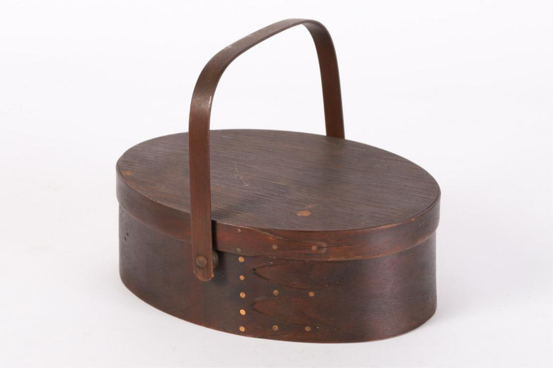 SHAKER (4) FINGER SILK-LINED 100SEWING CADDIE: Oval pantry-box form with good age and finger joints held by copper tacks, swing handle. Top opens to silk-lined interior . 3 x 8 3/4 x 6 1/2 inches
