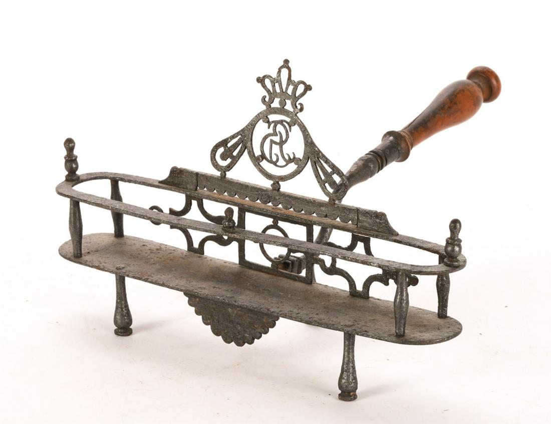 WROUGHT IRON TOASTER with KING GEORGE III MONOGRAM: (18th c) (3) Legged toaster with decorative fret work, finials and center drop. 8 x 12 x 13 inches.